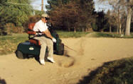 photo of player in single rider adaptive golf car in sand
trap