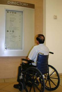 Person using a wheelchair at building directory