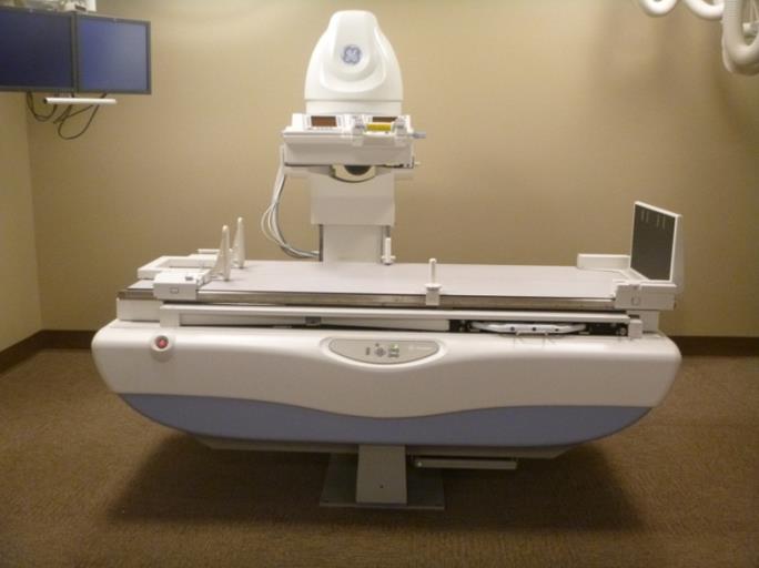 This picture shows a side view of an Angulating Radiographic and Fluoroscopic Exam Table whose fixed height is approximately 34.5 inches.  The height is the result of the design being able to angulate to perform certain types of diagnostic exams and also to accommodate imaging components under the table such as X-Ray tubes, high voltage generators, and detectors.  The table surface is also able to move in two directions horizontally.  Also note the equipment imaging components on the opposite side of where the patient transfers.