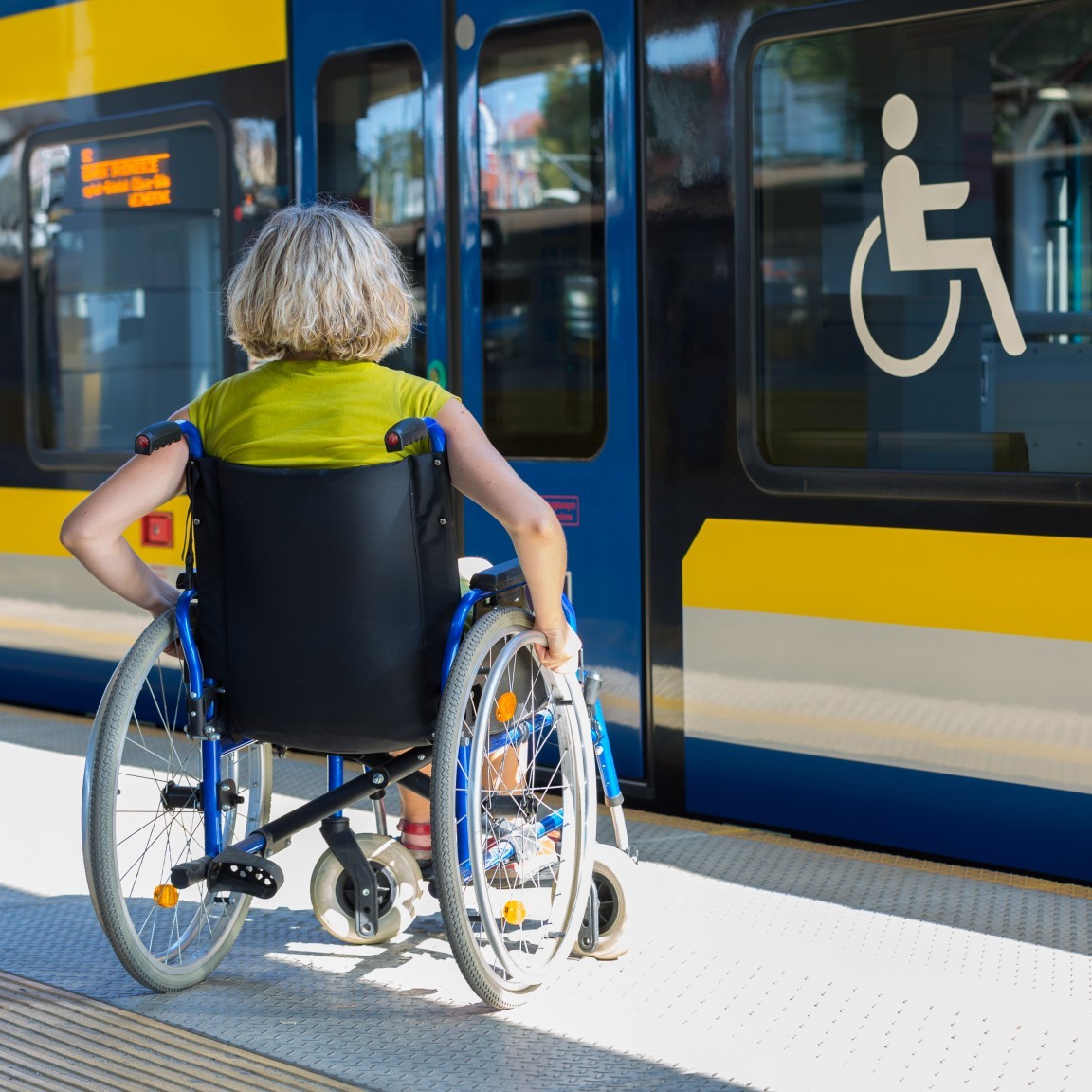 woman in wheelchair about to get on a bus with ISA in window (photo)
