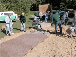 Figure 4---Leveling and compaction of binder--EWF mixture near junction with asphalt path.