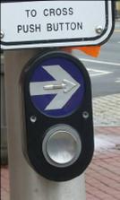 Pole-mounted oval unit with large silver arrow above large pushbutton. 