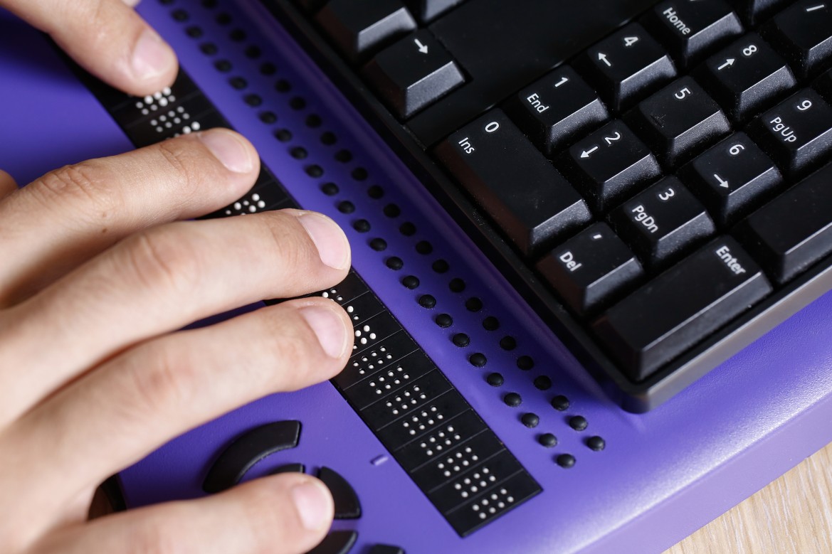 photo of hands typing on braille keyboard