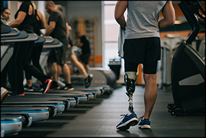 Row of treadmills with person with disability walking alongside them