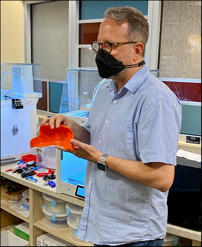 Inglis staff showing 3D-made object for accessible food plate