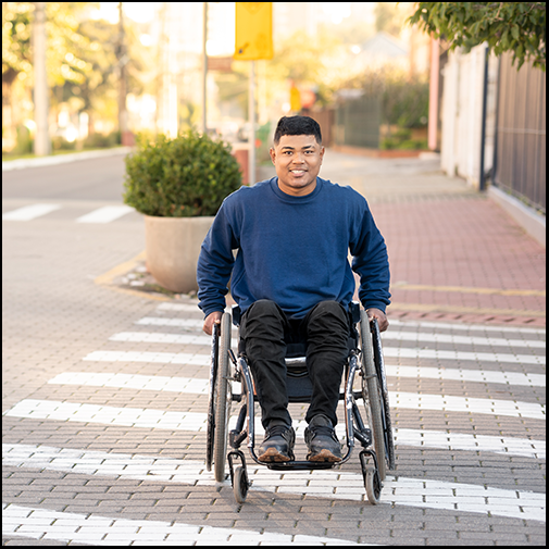 Wheelchair user crossing the street in the crosswalk